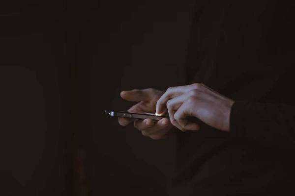 Una persona con un celular en las manos mientras ingresa a su billetera virtual.