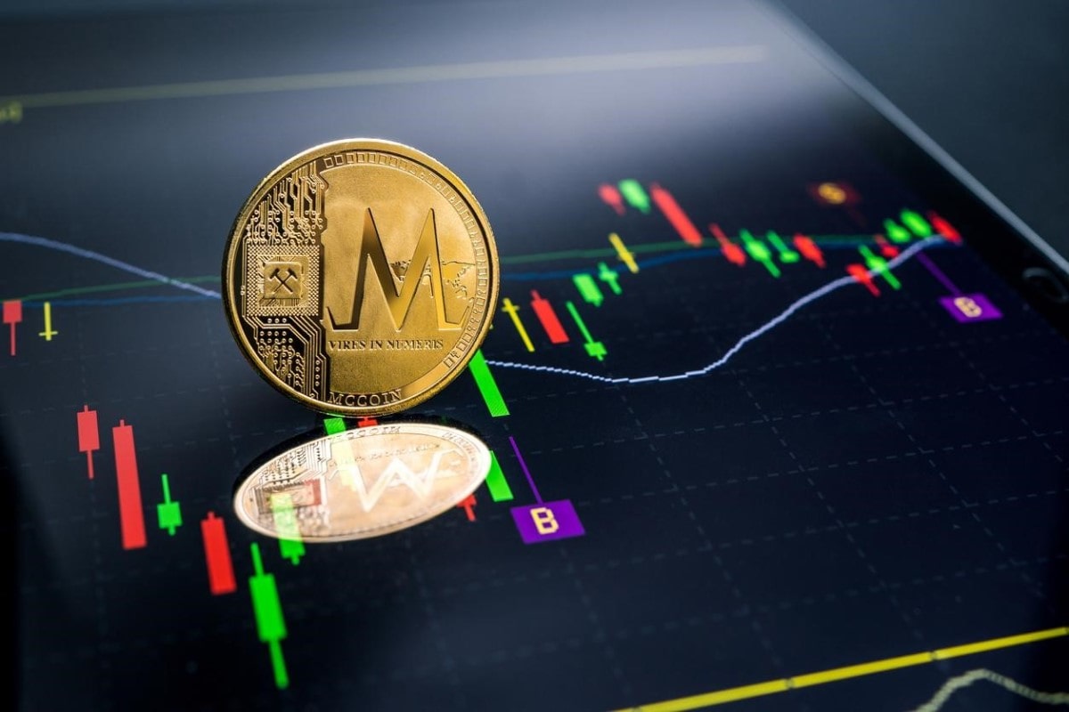 Una moneda Monero, una de las altcoins con más futuro, sobre un gráfico de tendencias.