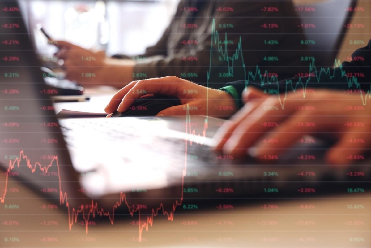 Inversionistas consultan en su laptop por acciones para invertir en la bolsa mexicana de valores.