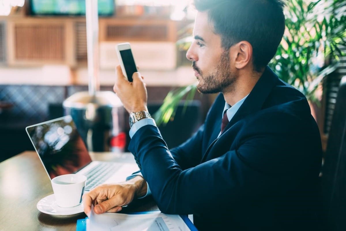 Un hombre joven investiga en su celular qué es la bolsa de valores.