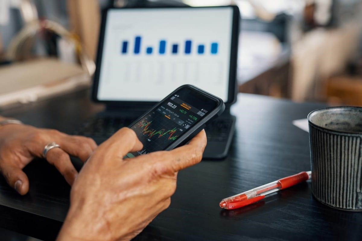 Trader revisa gráficos de brókers en Colombia a través de su celular.