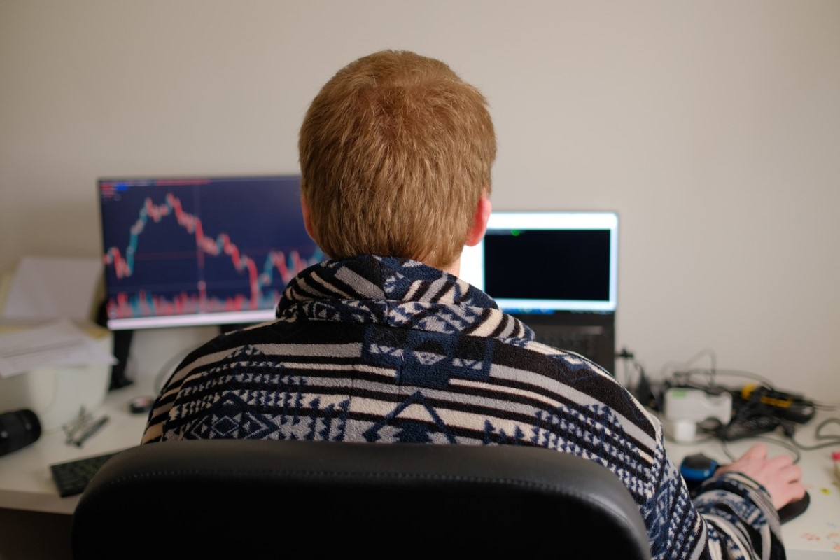 Un trader revisa en sus computadoras las predicciones de Cardano futuro.