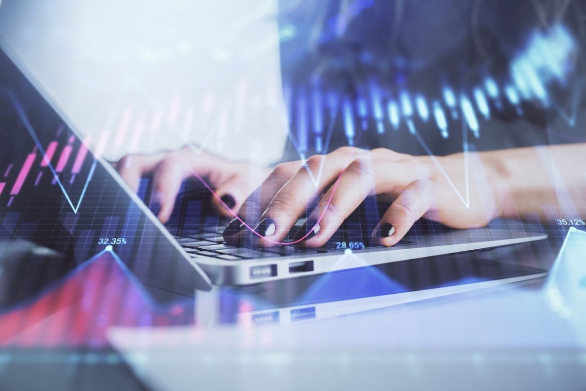 Una ejecutiva escribe en su computador mientras usa Chat GPT para trading