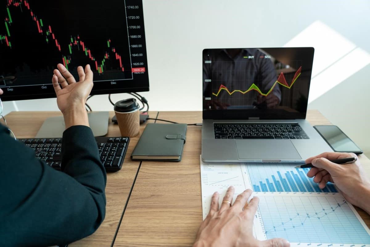 Inversionistas estudian tendencias en sus computadores antes de comprar acciones en Ecuador.