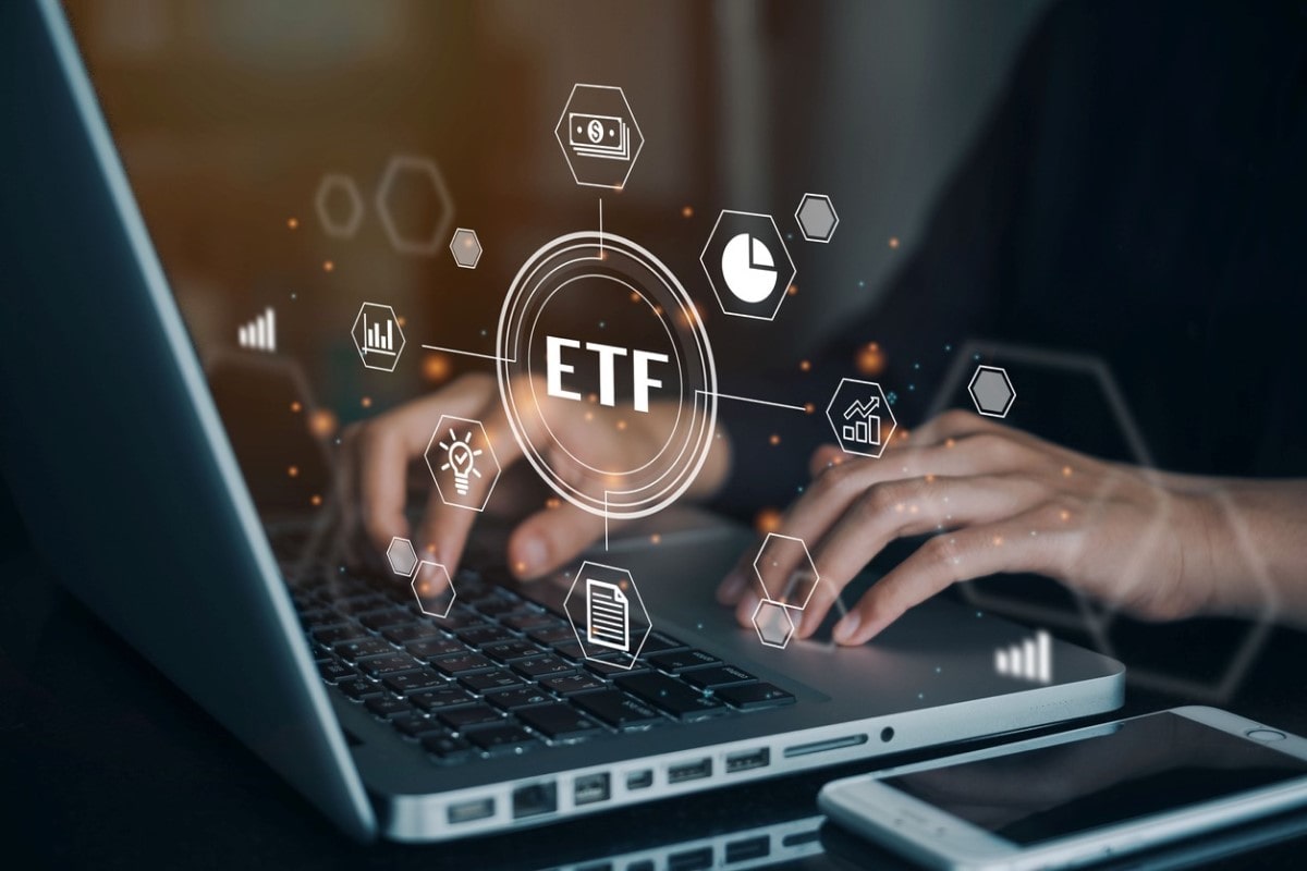 Hombre trabaja en su computadora con ETFS más rentables.