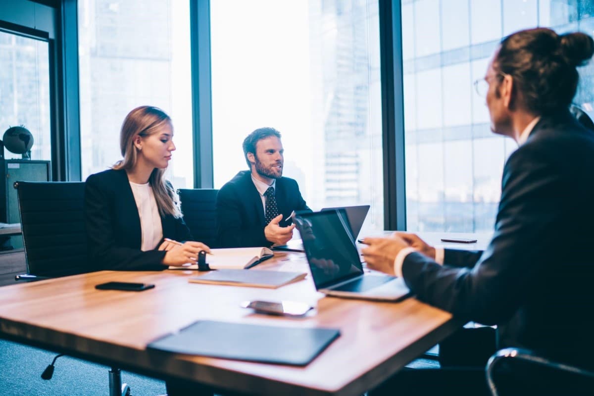 Inversionistas jóvenes conversan en una junta sobre los fondos de cobertura.