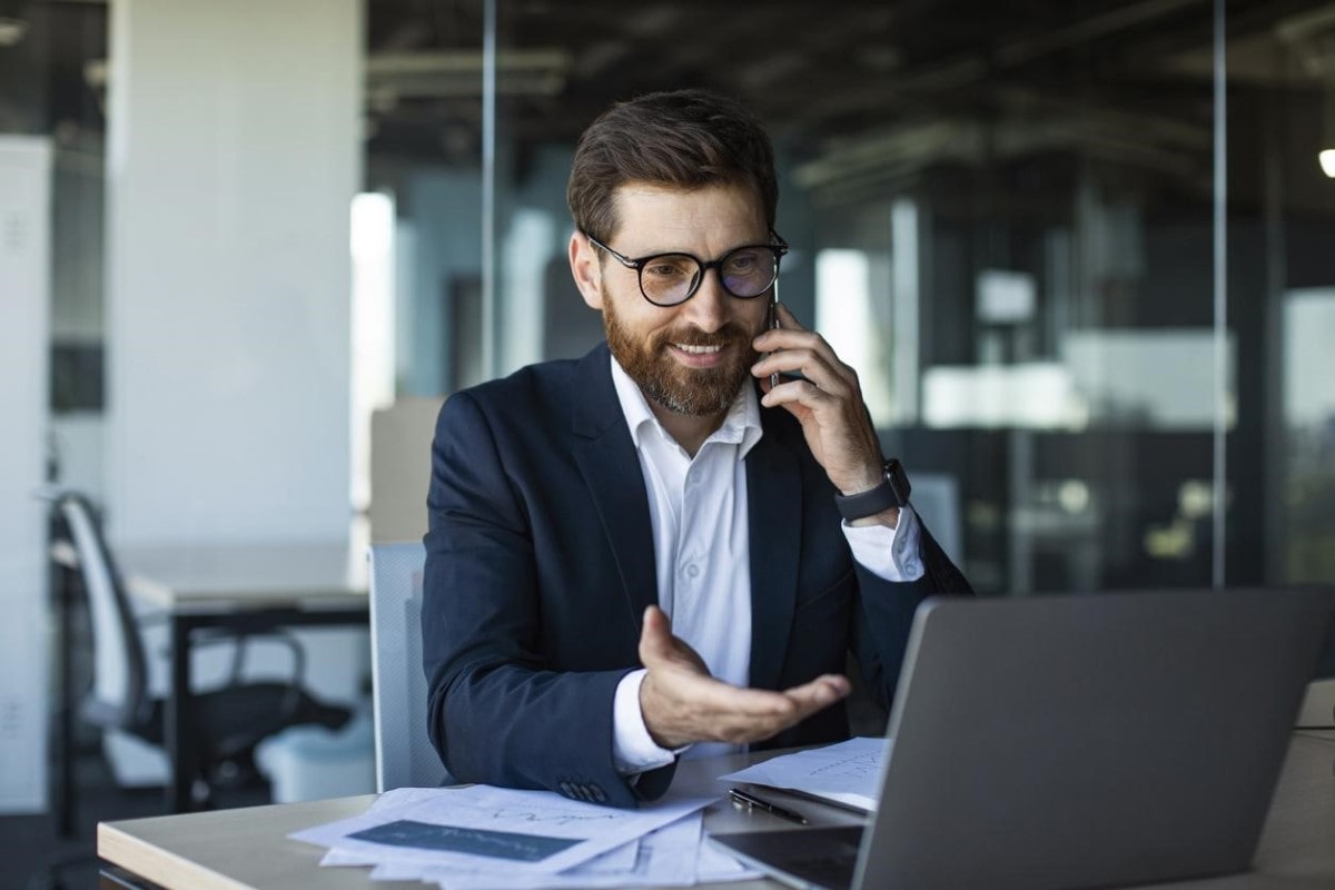 Ejecutivo conversa por teléfono sobre instrumentos financieros para invertir.