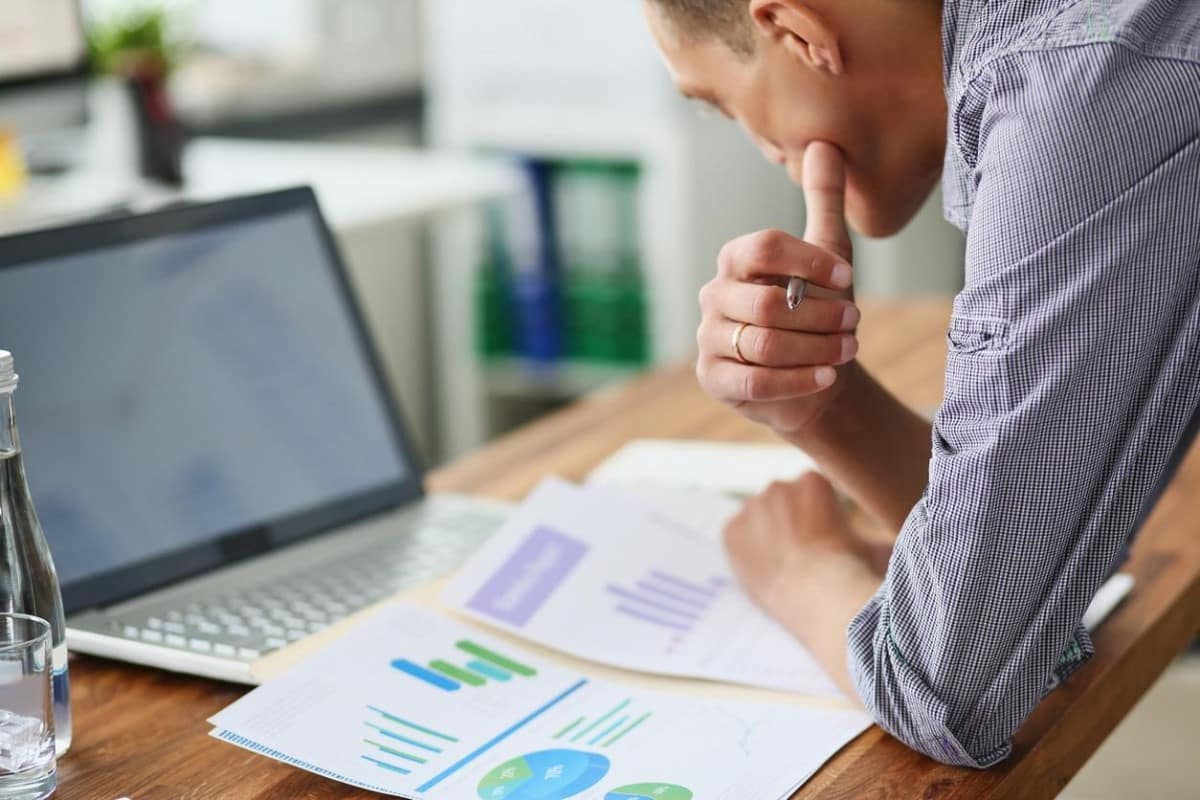 Un hombre de negocios analiza gráficos para determinar cómo invertir en divisas emergentes.