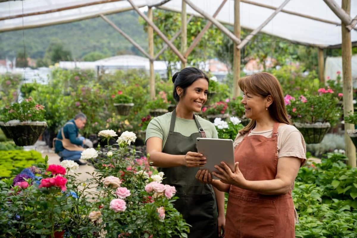 Empleadas hacen inventario en un centro de jardinería. Los negocios verdes son una de las mejores inversiones en Colombia.