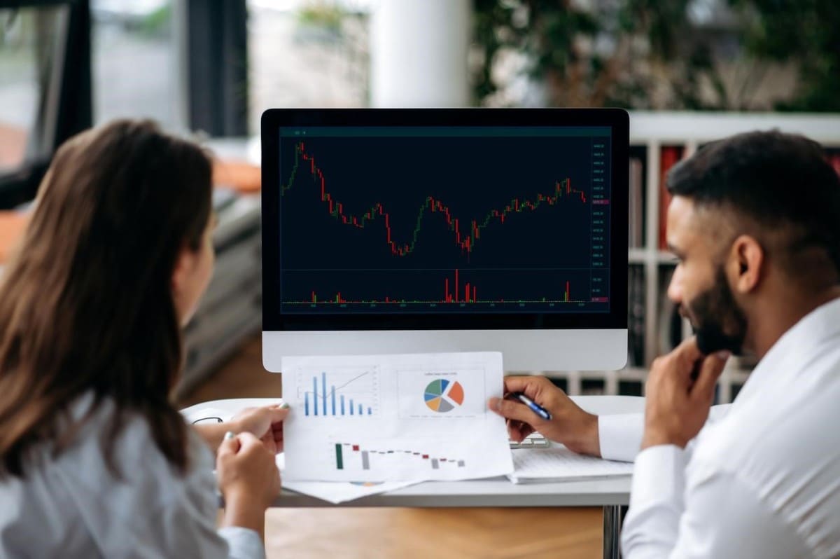 Dos inversionistas revisan gráficos antes de operar en el mercado de opciones.