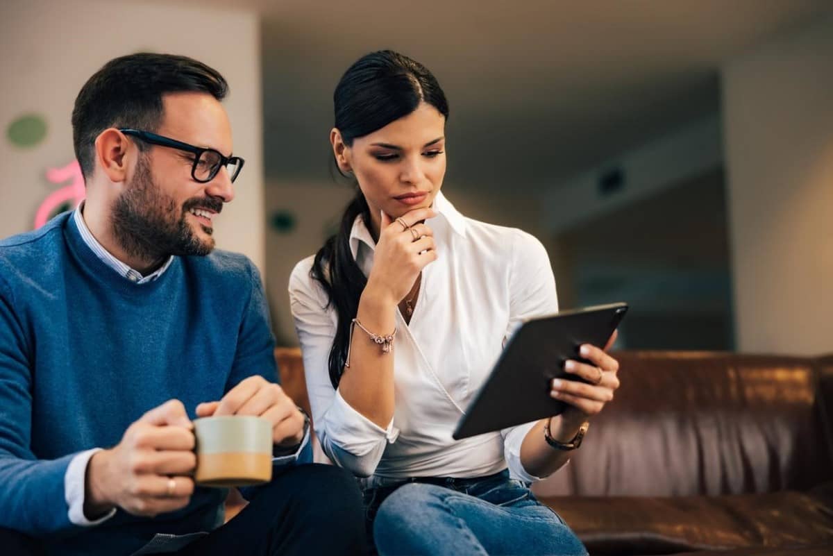 Un par de inversionistas investigan en una tablet sobre mercados emergentes.