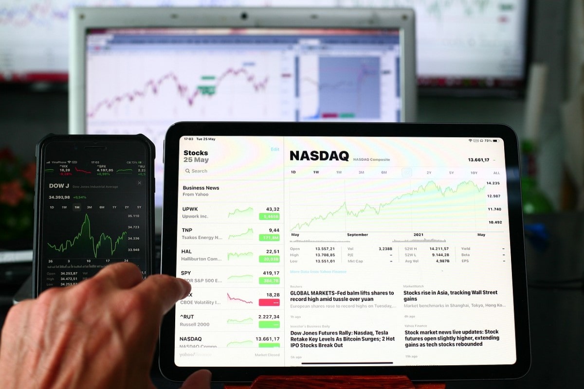 Persona viendo una computadora con gráficos sobre NASDAQ.