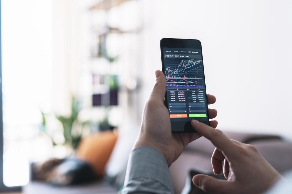 Un trader revisa tendencias antes de comprar y vender monedas digitales bajo la estrategia de arbitraje de criptomonedas.