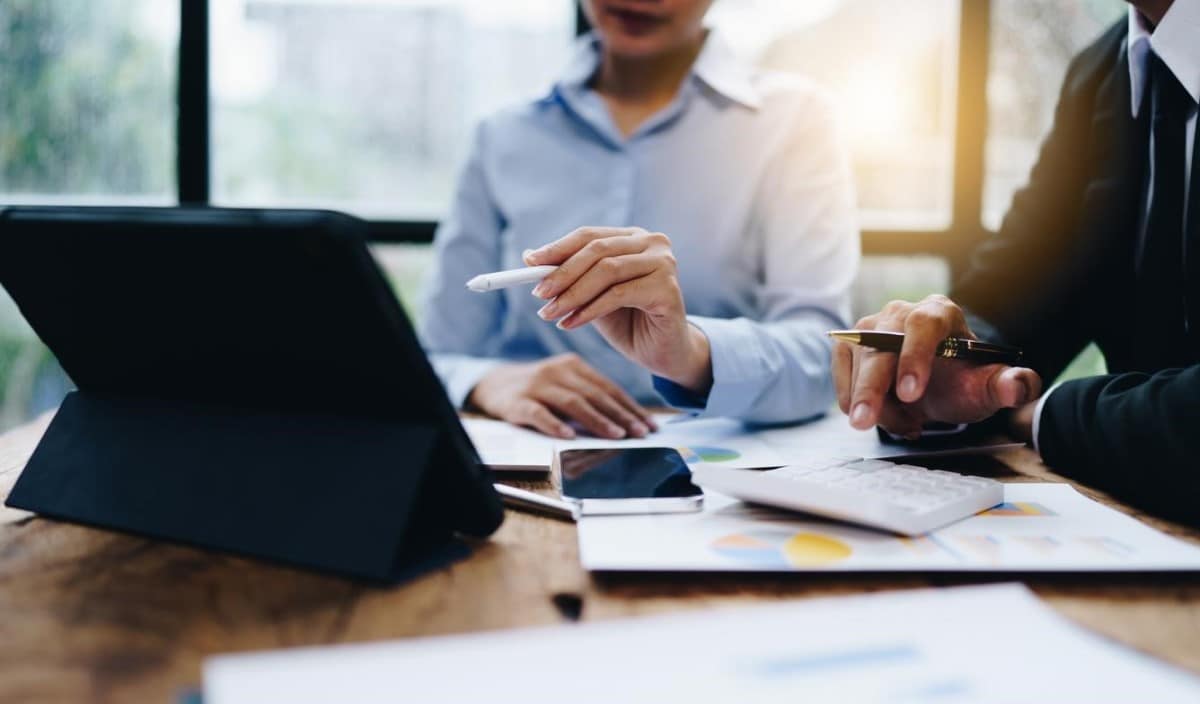 Compañeros de negocios calculan la rentabilidad de una empresa.