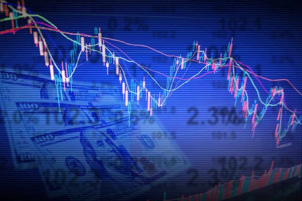 Billetes de 100 dólares al fondo de un gráfico. Conoce cómo la tasa de cambio influye en el mercado de divisas.
