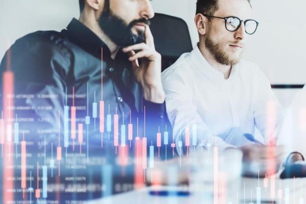 Un par de empresarios analizan un gráfico de velas.