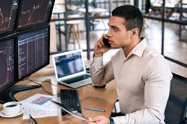 Joven inversor conversa por celular sobre cómo operar en la bolsa de valores Perú.