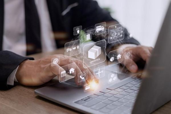 Empresario verifica la cadena de suministro en su laptop con tecnología blockchain.