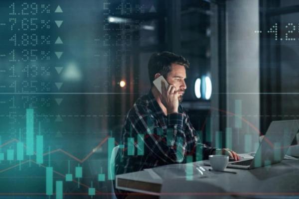 Trader investiga en su laptop sobre los tipos de acciones para invertir y tendencias.