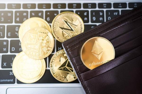 ETH y otras cripto sobre un teclado. Descubre cómo invertir en criptomonedas.