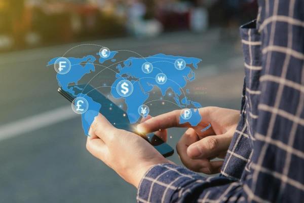 Un trabajador realiza desde el celular el envío de remesas a otro país.