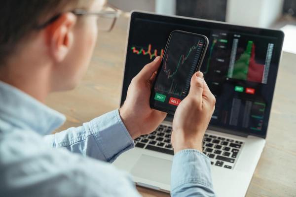 Hombre revisa gráfica de criptomonedas antes de invertir a través de brókers México.