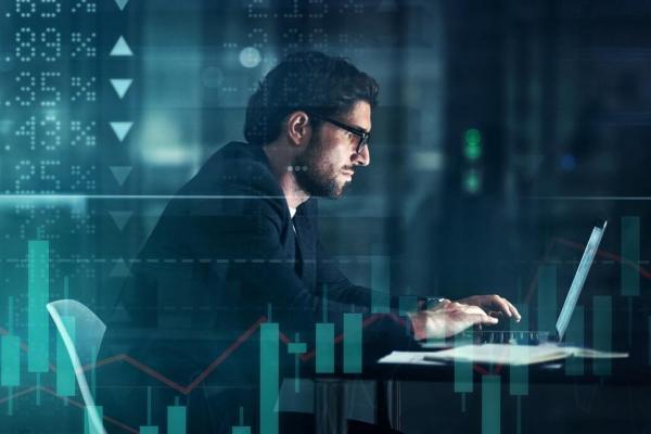 Un inversionista investiga en su laptop sobre mercados financieros.