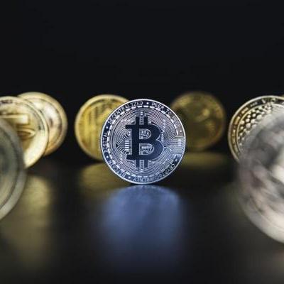 Bitcoin y otras crypto en un fondo oscuro. Descubre qué son las criptomonedas.