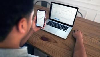 Un bróker analizando gráficos en una computadora