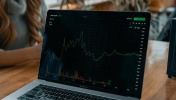 Computadora con gráficos sobre el comportamiento del Dow Jones.