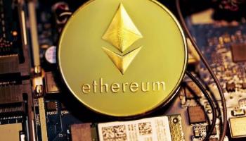 Moneda grabada con la palabra “Ethereum” y el logotipo, sobre una placa de computadora. 