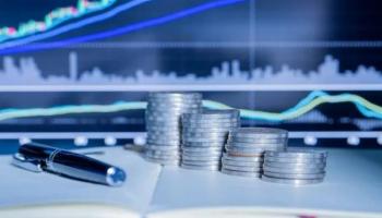 Monedas frente a un monitor con gráficos