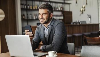 Un hombre de negocios analiza en su celular los resultados de una inversión pasiva.