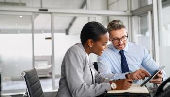 Empresarios analizan en una tablet activos virtuales en los que pueden invertir.