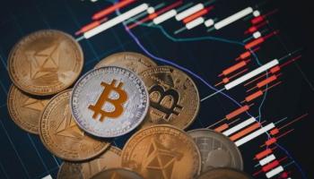 Criptomonedas sobre un gráfico de velas. La forma más segura de proteger estos activos son las cold wallets.