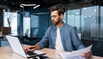 Un hombre estudia en su computador algunos derivados financieros.