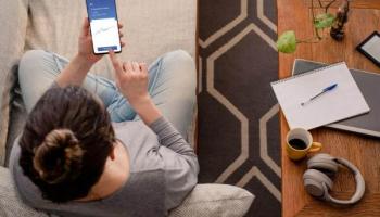 Joven trader revisa en su celular aplicaciones para invertir en la Bolsa.