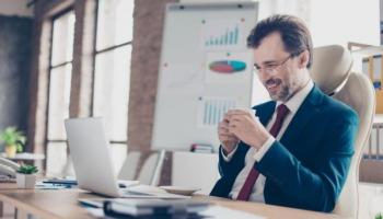 Empresario analiza en su computadora cómo comprar acciones en Perú.