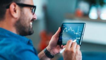 Hombre práctica trading desde su tablet. Descubre en esta nota qué es un trader.