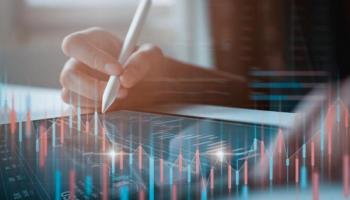 Un trader revisa gráficos de indicadores económicos en su tablet.