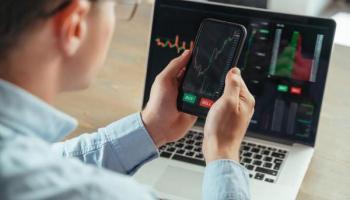 Hombre revisa gráfica de criptomonedas antes de invertir a través de brókers México.