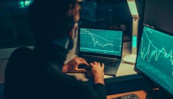 Un inversionista analiza tendencias en sus computadoras. Conoce aquí qué es drawdown.