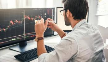 Trader analiza en su computadora las tendencias de una nueva criptomoneda.