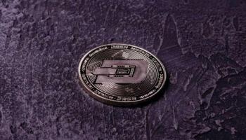 Una criptomoneda en un fondo oscuro. Descubre las predicciones del precio del Dash.