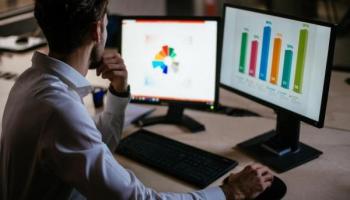 Un empresario realiza en sus computadoras un análisis de oportunidades de mercado.