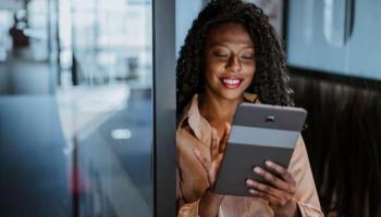 Mujer de negocios investiga en su tablet cómo invertir en Index Chile.