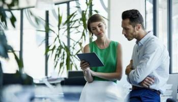 Una pareja de empresarios analiza en su tablet las mejores inversiones en Colombia.