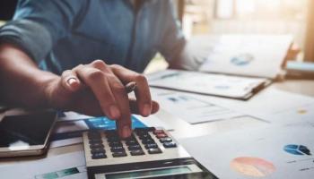 Empresario revisa cifras y gráficos para calcular la depreciación de un activo.