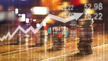 Monedas sobre una mesa y gráficos de tendencia alcista. Foto conceptual sobre invertir en divisas emergentes.